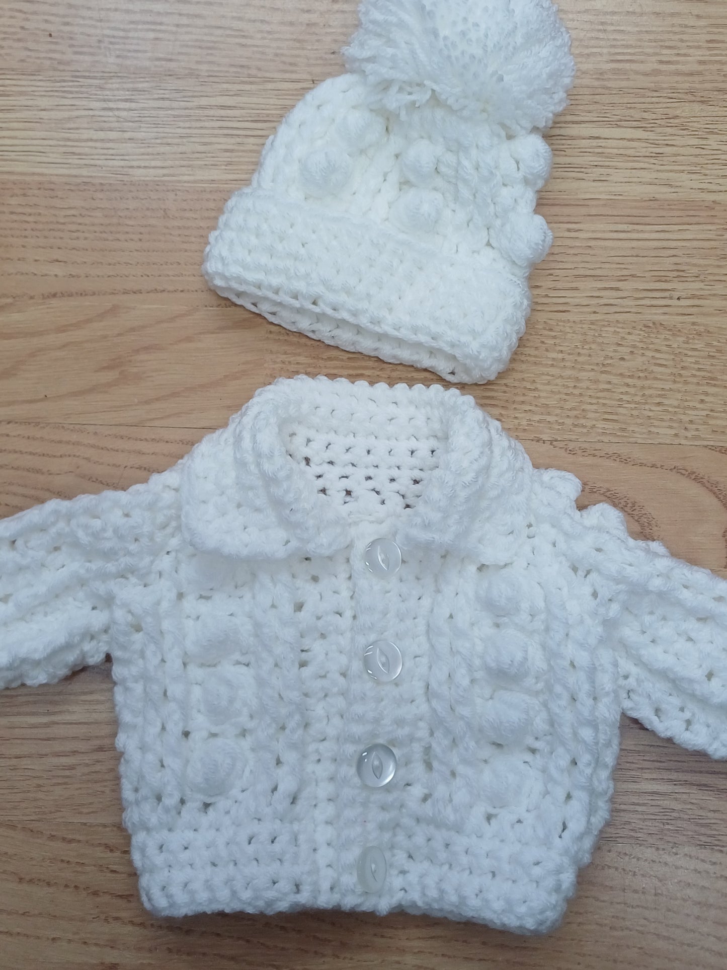 Babys handmade crocheted cardigan and pom hat set