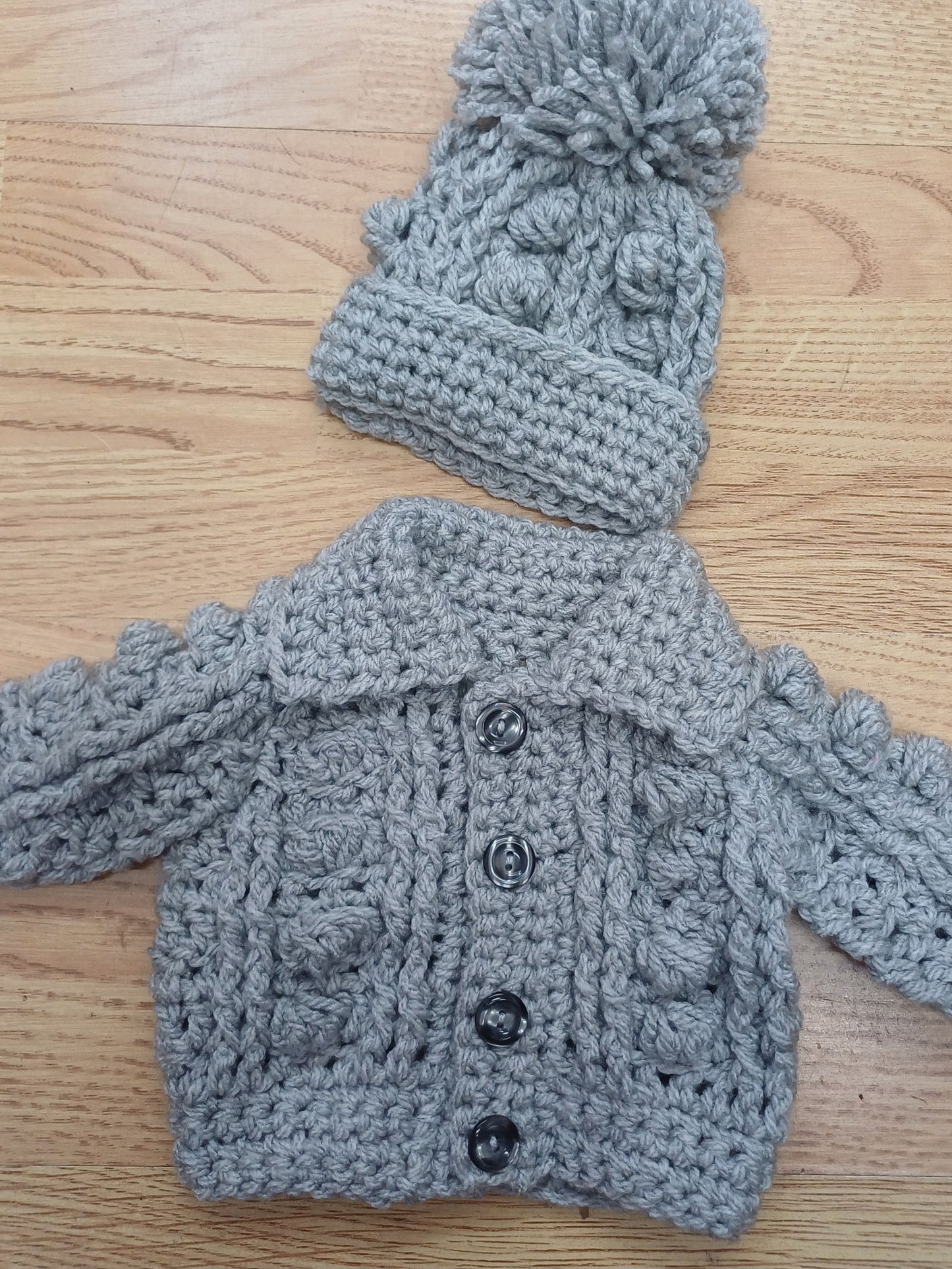 Babys handmade crocheted cardigan and pom hat set