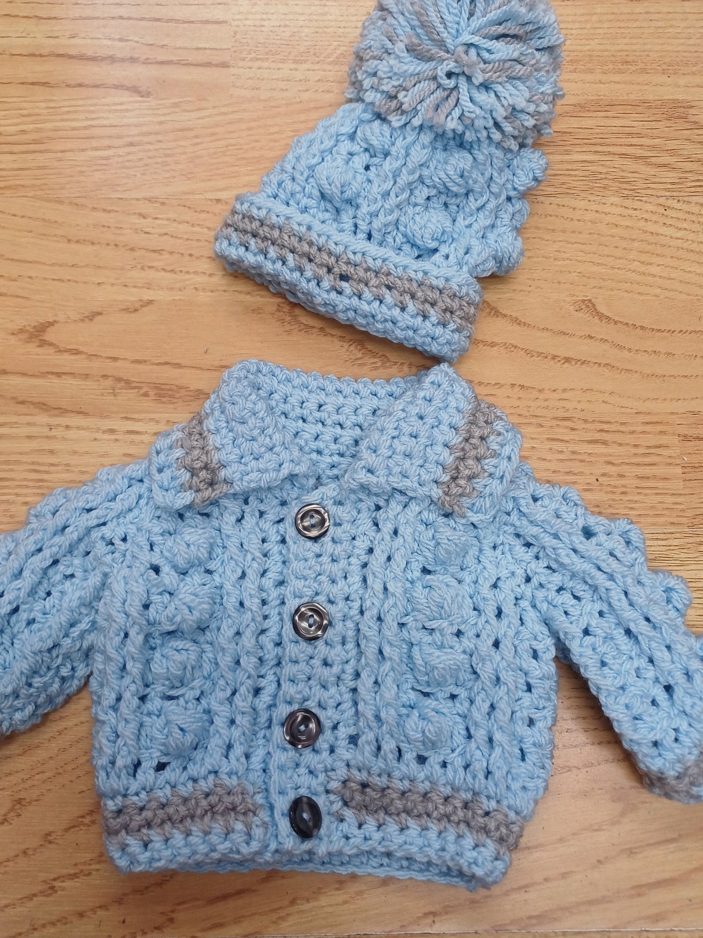 Babys handmade crocheted cardigan and pom hat set