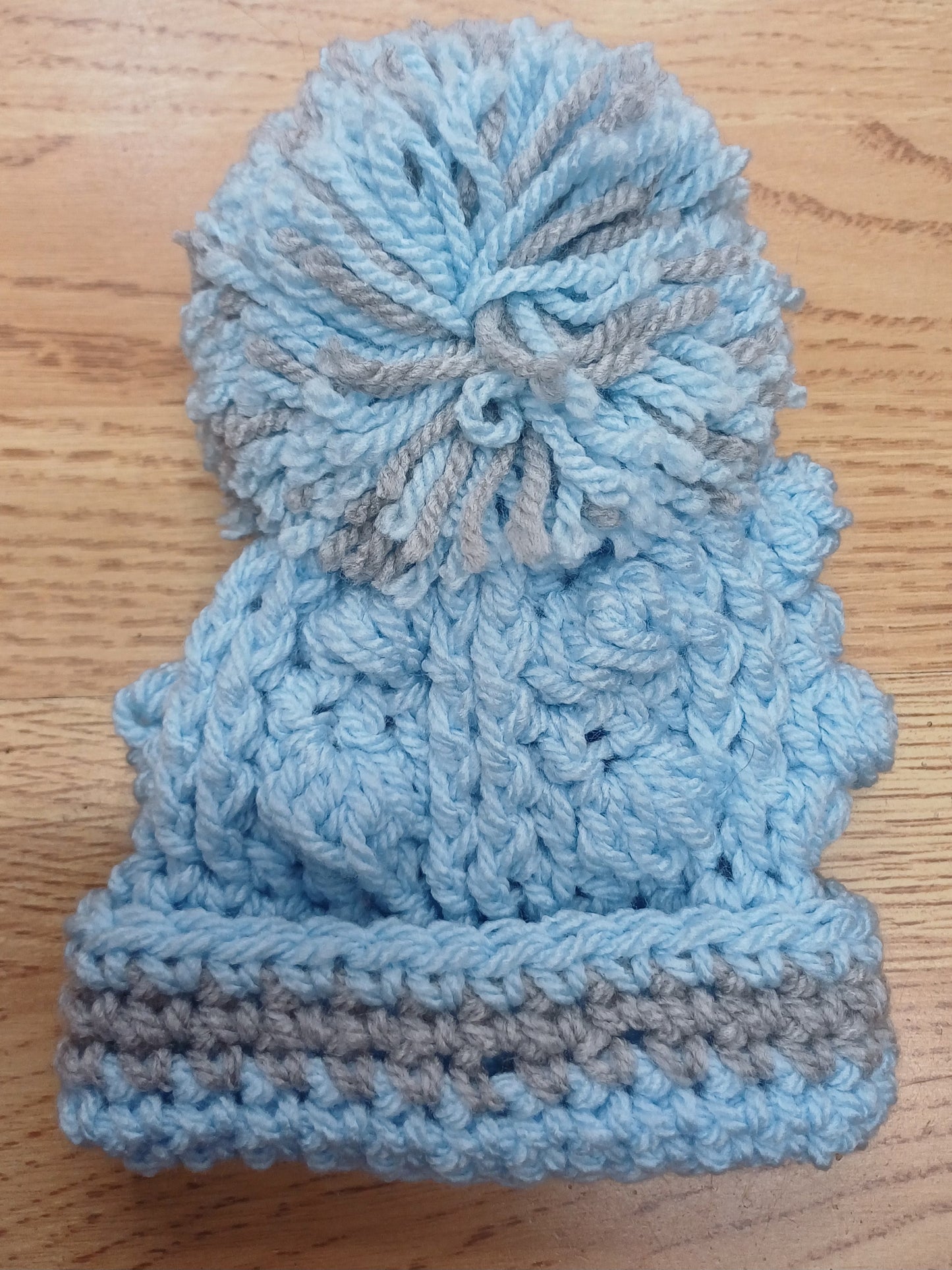 Babys handmade crocheted cardigan and pom hat set